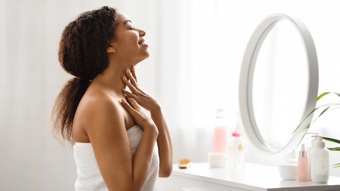 This is a photo of a young, Black woman during a morning moisturizing routine.