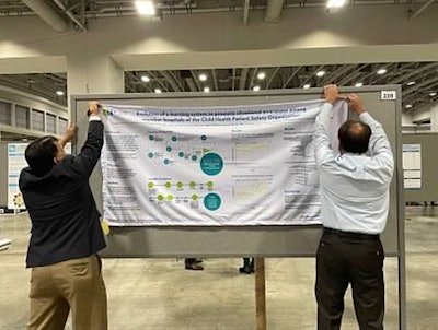 Dr. Shah and his co-author hang their scientific poster at a national meeting.