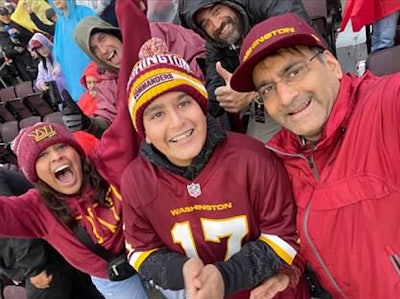 Dr. Shah (right) cheers on the Washington Commanders football team with his children.