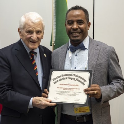 Muluken Bekele Wondimagegnehu, MD (right), receives a Eugene N. Myers, MD Global Education Fund Award from the fund’s namesake, Eugene N. Myers, MD, FRCS, Edin(Hon).
