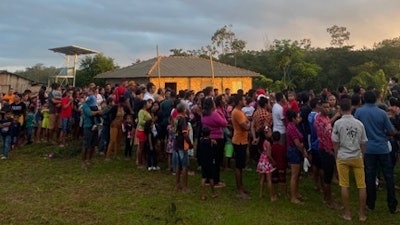 Patients from riverside communities stand in line before sunrise to receive free treatment from the ship’s team.