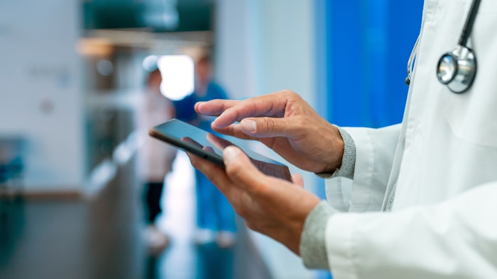 Image of medical person holding a tablet.