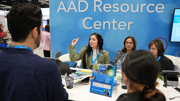 AAD Resource Center booth with staff members at conference, discussing materials