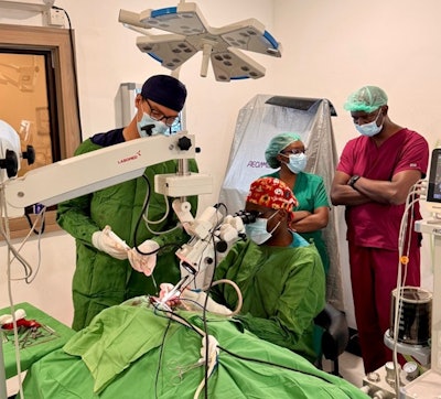 The author and Dr. Mercredi exchange roles while performing a revision canal wall down mastoidectomy under the watchful eye of Dr. Ayugi (red scrubs).