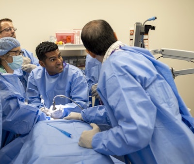 Video laryngoscopy is utilized for urgent intubation in this difficult airway case.