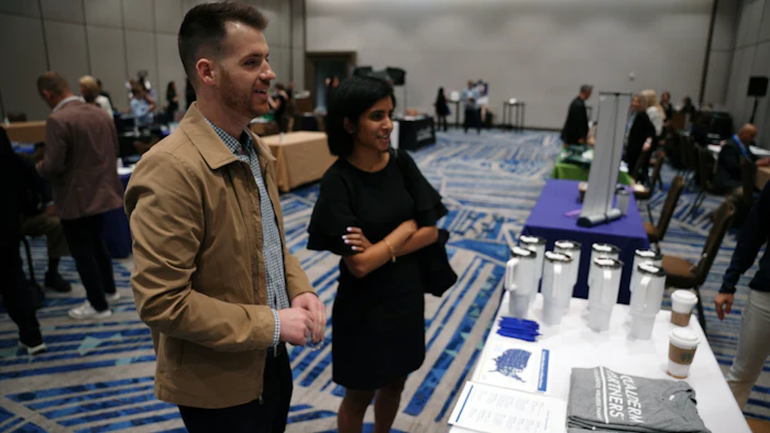 Professional conference scene with attendees near branded display table