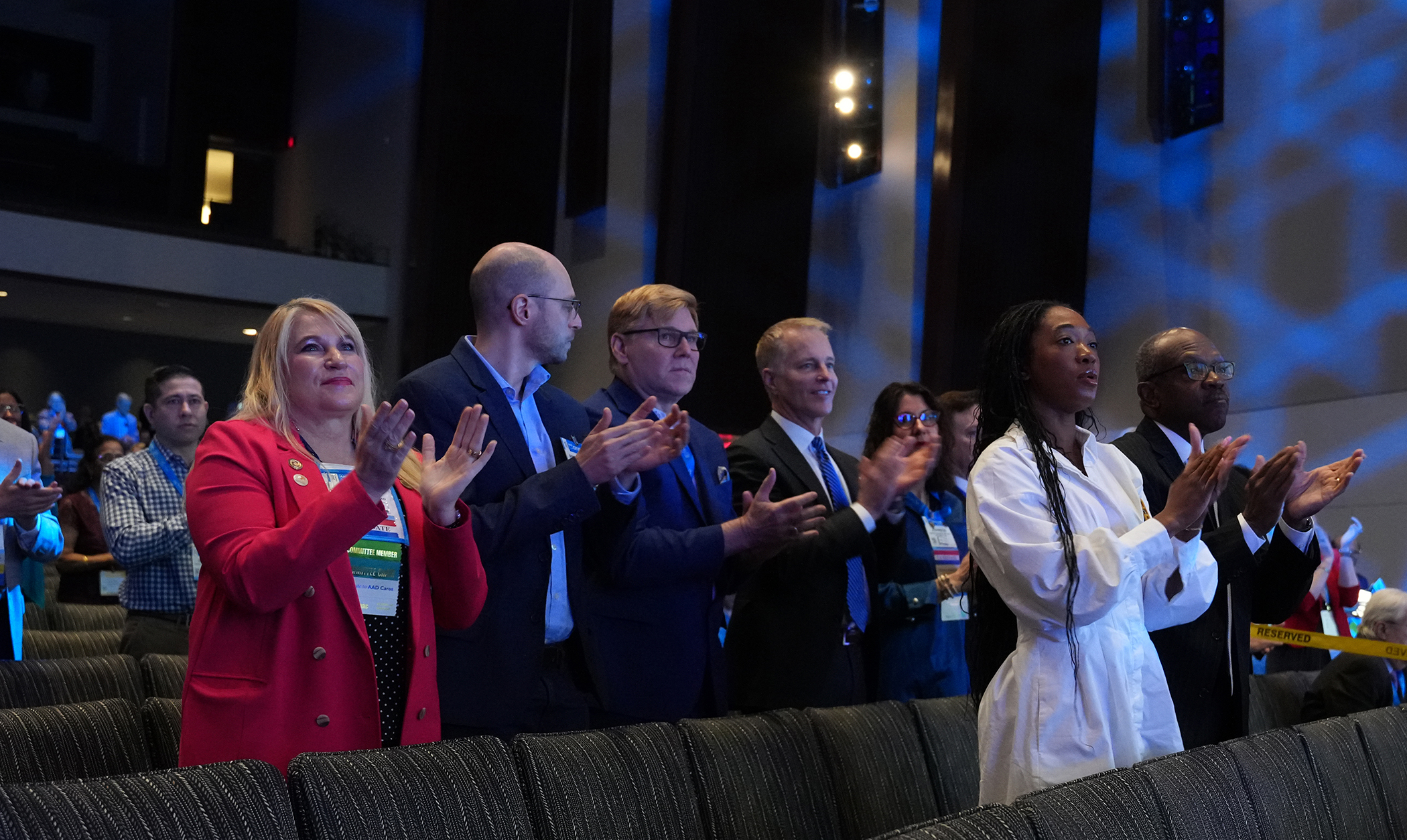 Diverse group of professionals applauding at a conference or event