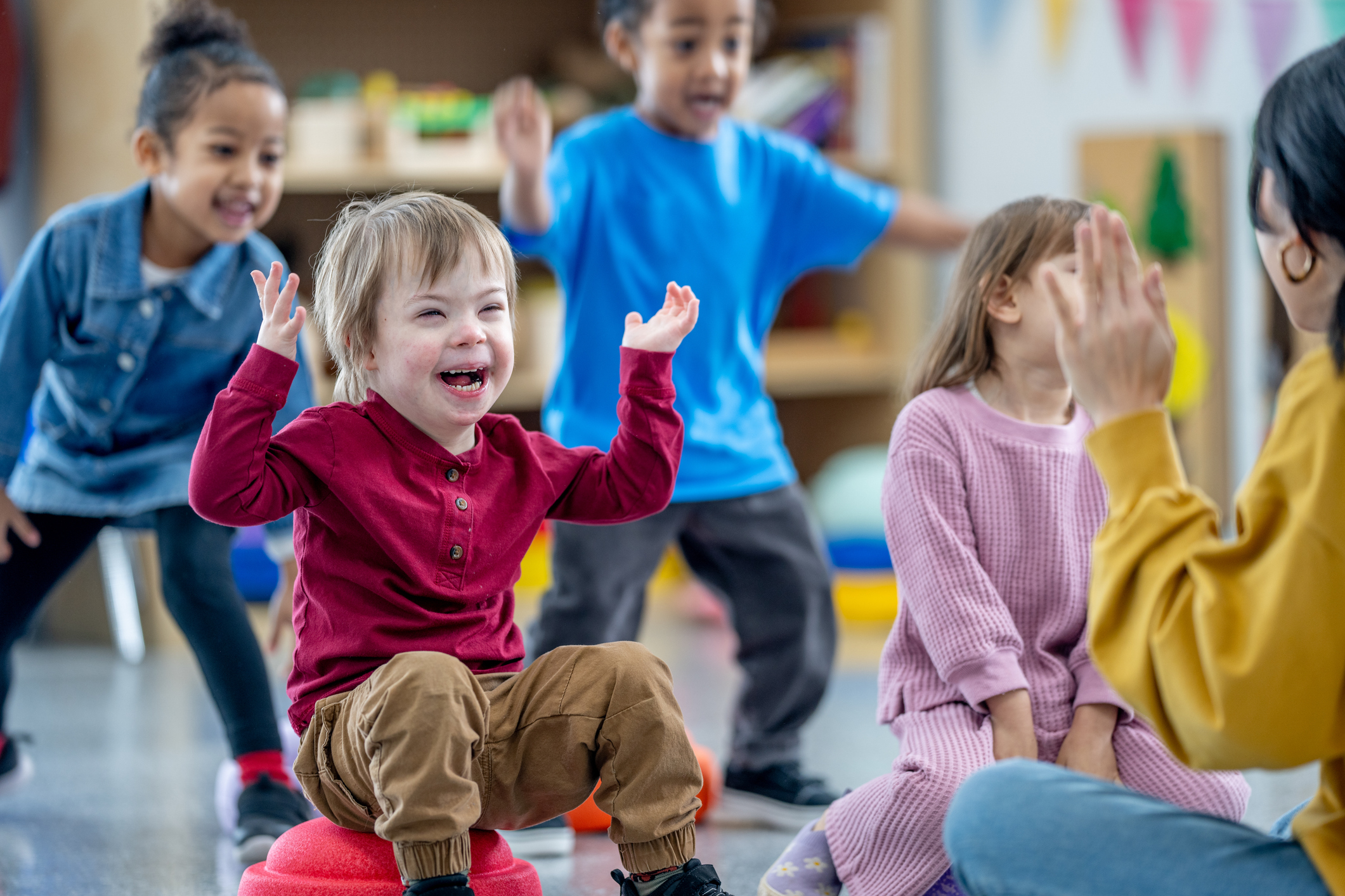 Young children playing and laughing together in a colorful classroom