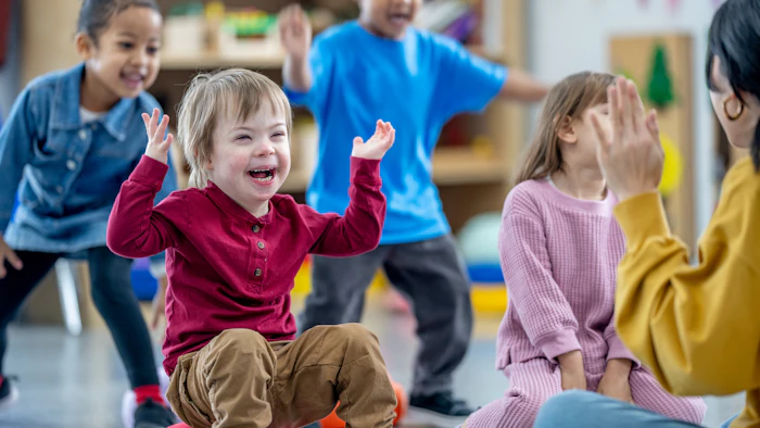 Young children playing and laughing together in a colorful classroom