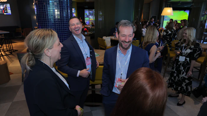 Professionals networking and laughing together in a modern event space