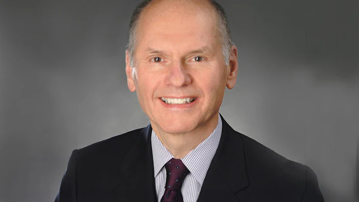 Smiling mature business executive in black suit and purple tie
