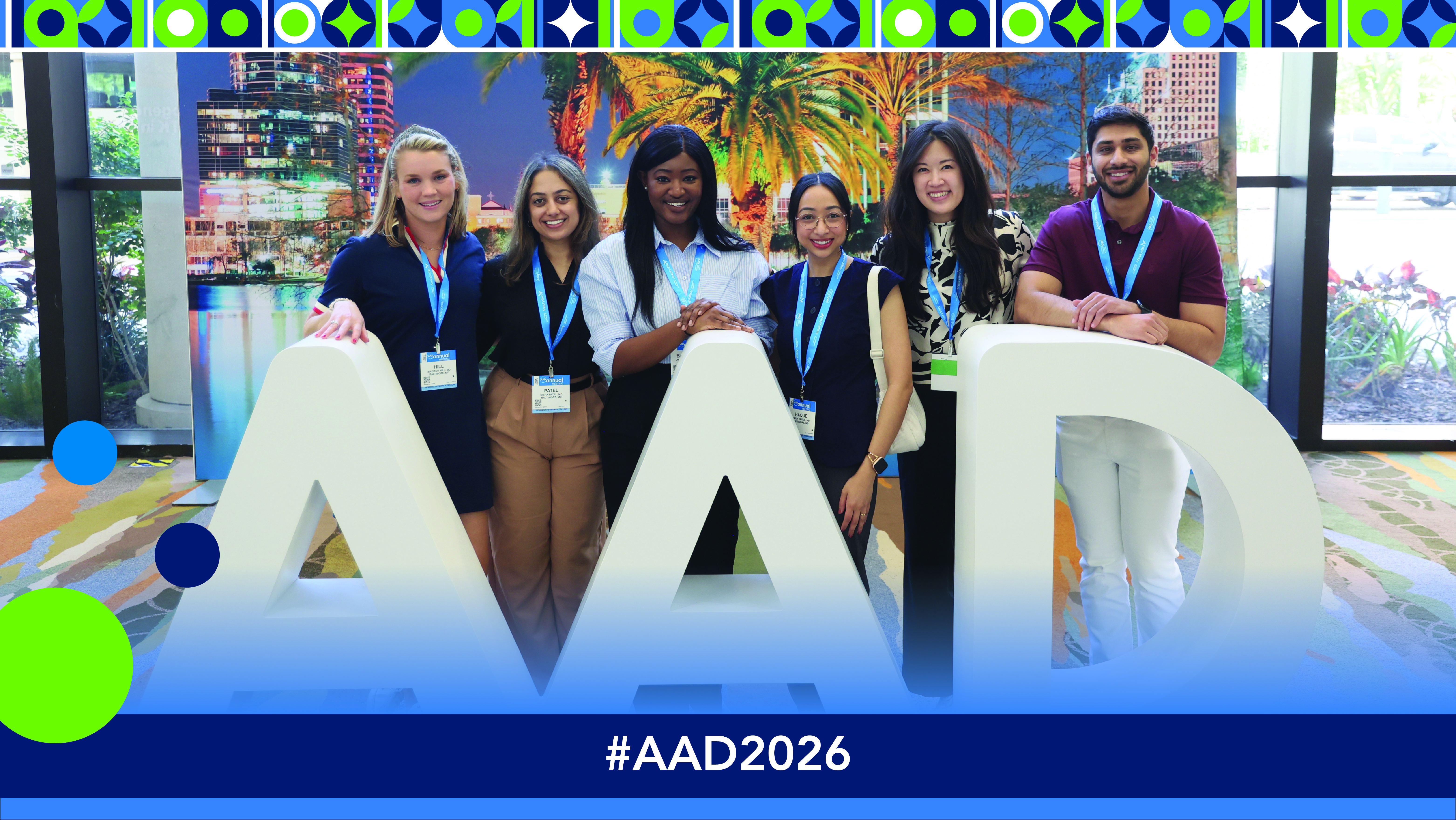 Team of six professionals wearing blue lanyards posing with large AAD letters at conference event