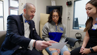 Dr. Bush in the Outreach Clinic with a patient and staff audiologist.